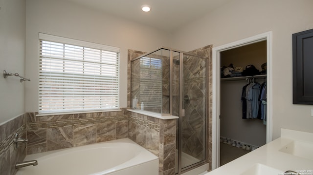 bathroom featuring separate shower and tub and vanity