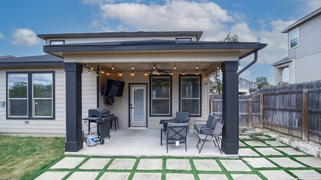 back of property with ceiling fan and a patio area