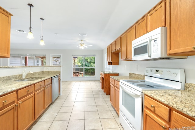 kitchen with pendant lighting, white appliances, light stone counters, sink, and ceiling fan