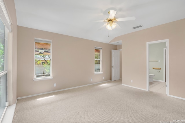 unfurnished bedroom with ceiling fan, light carpet, ensuite bathroom, and multiple windows