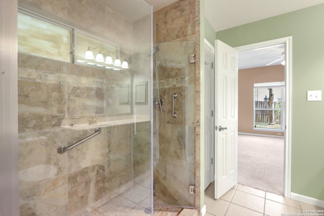 bathroom featuring a shower with door, ceiling fan, and tile patterned floors