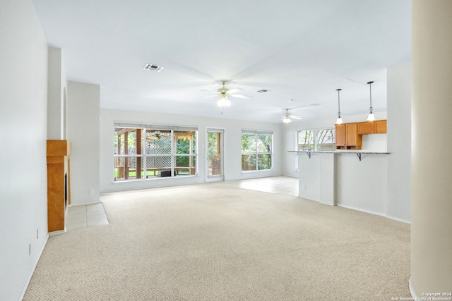 unfurnished living room with light carpet and ceiling fan