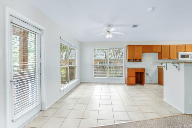 kitchen with plenty of natural light, light tile patterned floors, and ceiling fan