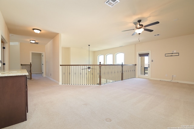 empty room with light colored carpet and ceiling fan