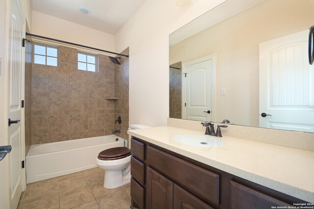 full bathroom featuring tiled shower / bath combo, vanity, toilet, and tile patterned floors