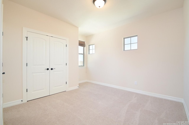 unfurnished bedroom with a closet, carpet, and baseboards