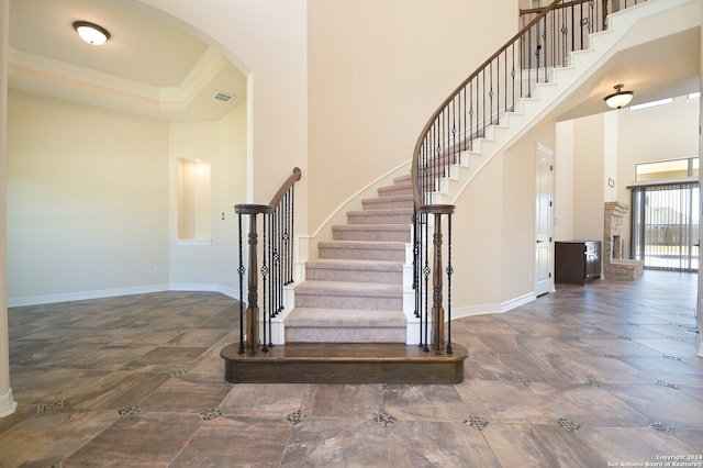 stairs featuring a high ceiling and crown molding