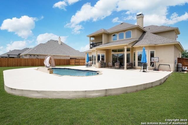 back of house with a yard, a fenced backyard, a fenced in pool, and a patio