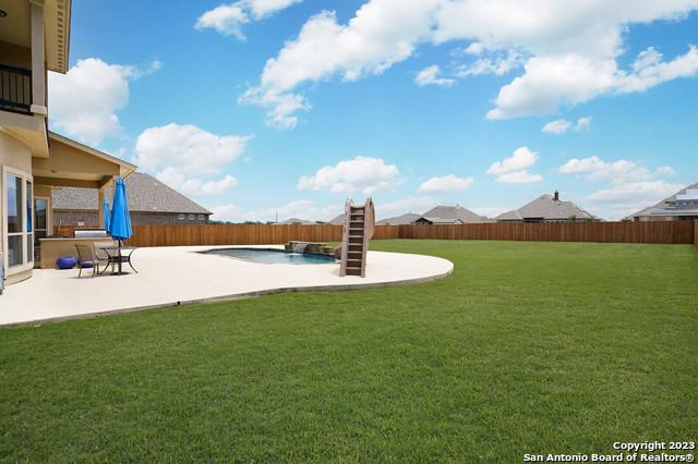 view of yard with a patio area, a fenced backyard, and a fenced in pool