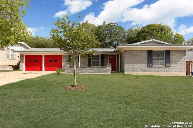 view of front of property with a garage and a front lawn