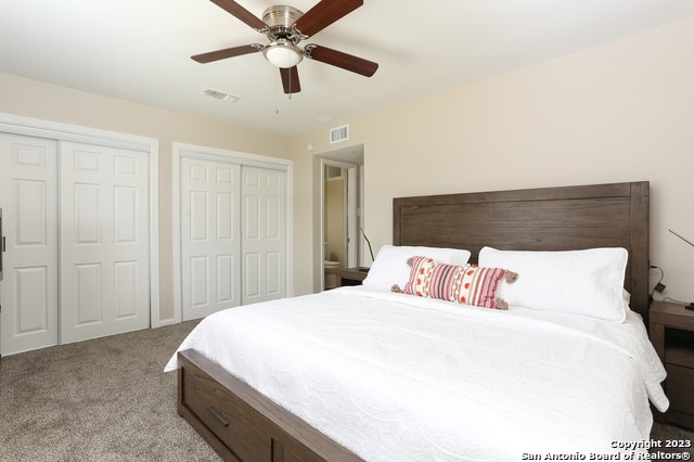 bedroom featuring two closets, ceiling fan, and light colored carpet