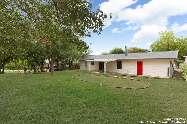 rear view of property with a lawn