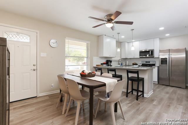 dining area with ceiling fan and light hardwood / wood-style floors