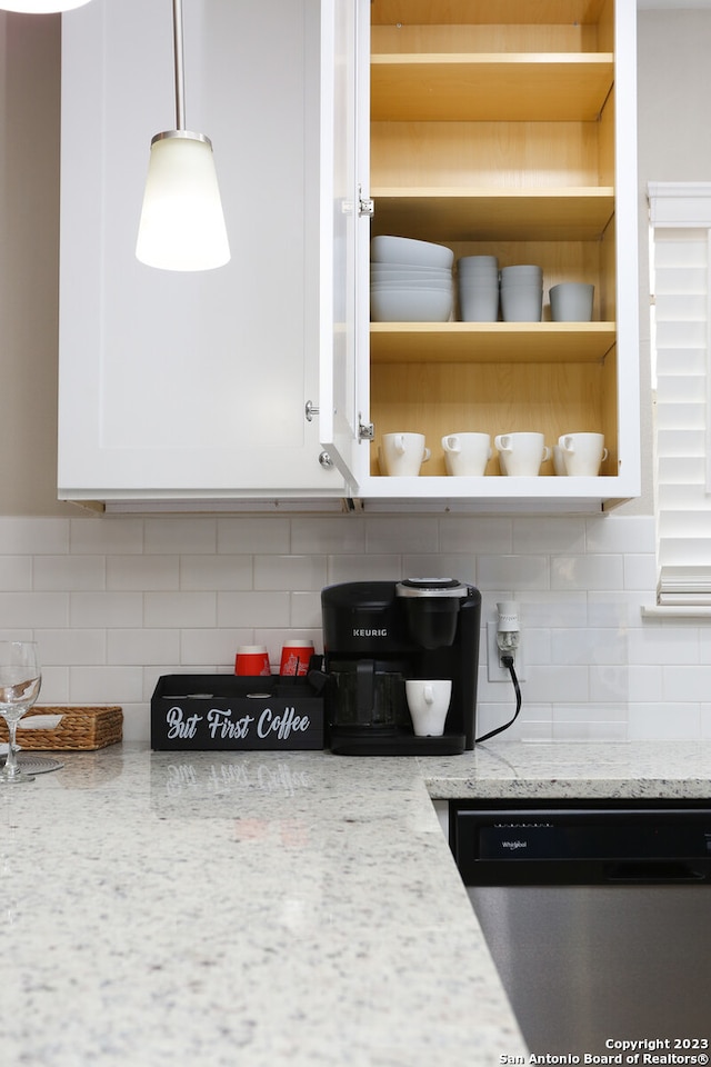 kitchen with stainless steel dishwasher, light stone countertops, and decorative backsplash