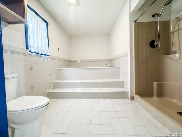 bathroom with tile walls, independent shower and bath, toilet, and tile patterned floors