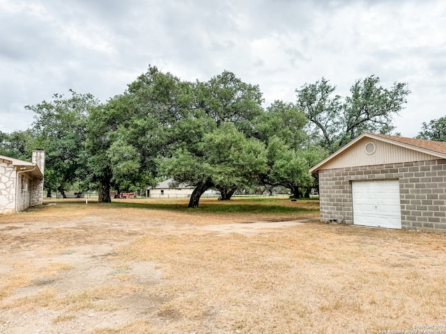 view of yard featuring a garage and an outdoor structure