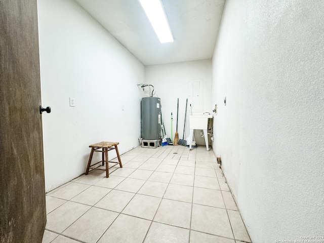 interior space featuring light tile patterned floors, sink, and water heater