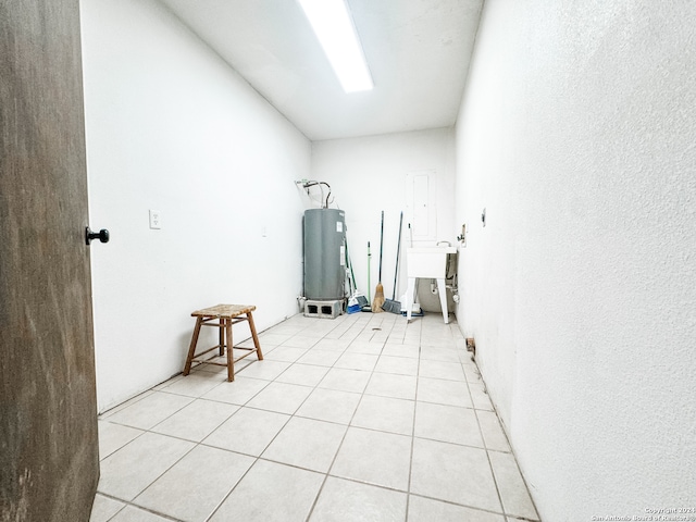 interior space with sink, light tile patterned floors, and water heater