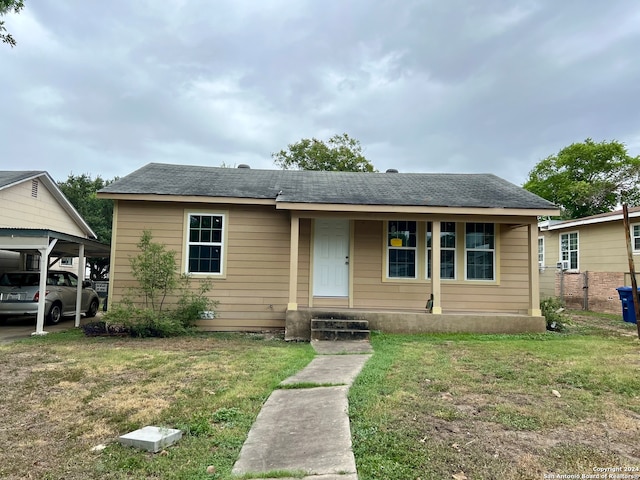 view of front facade with a porch, a carport, and a front yard