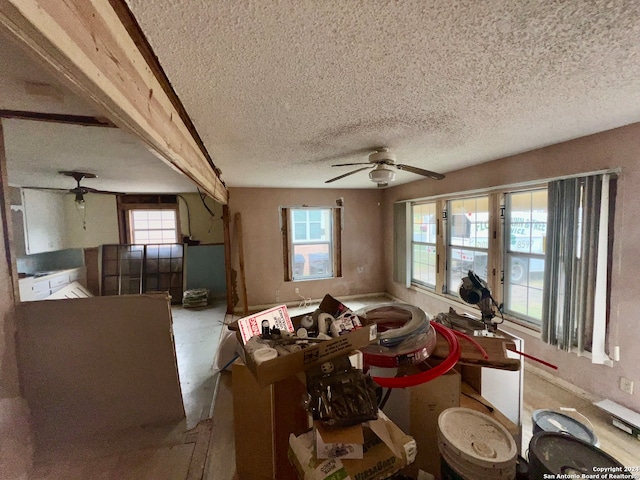 living room featuring a textured ceiling, plenty of natural light, and ceiling fan