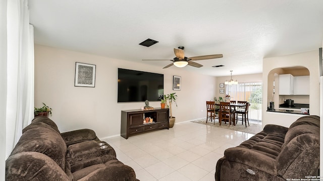 living room featuring baseboards, light tile patterned flooring, visible vents, and a ceiling fan