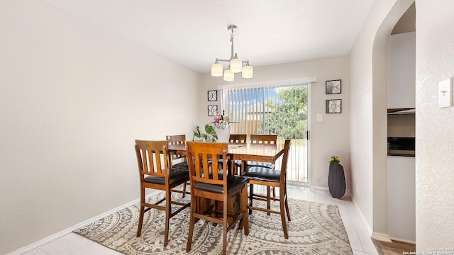 dining space with baseboards, arched walkways, a chandelier, and tile patterned flooring