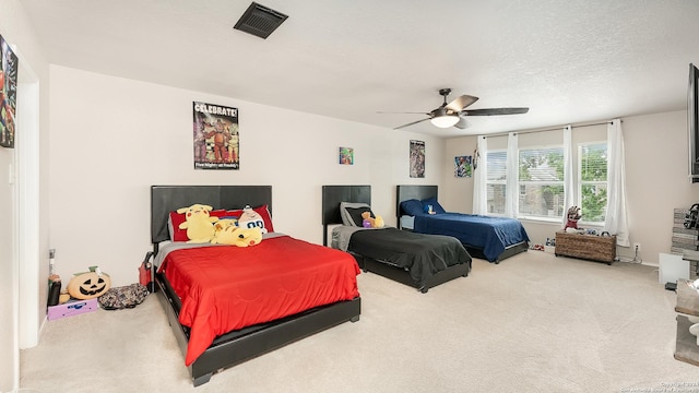 bedroom with a textured ceiling, carpet floors, visible vents, and a ceiling fan