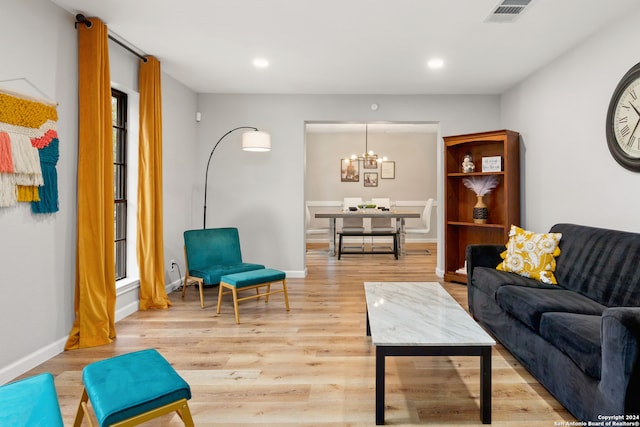 living room featuring light hardwood / wood-style floors, a notable chandelier, and plenty of natural light