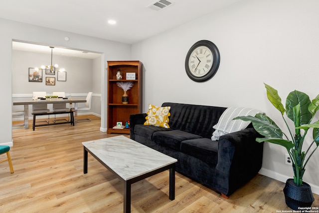 living room featuring light hardwood / wood-style flooring and a notable chandelier