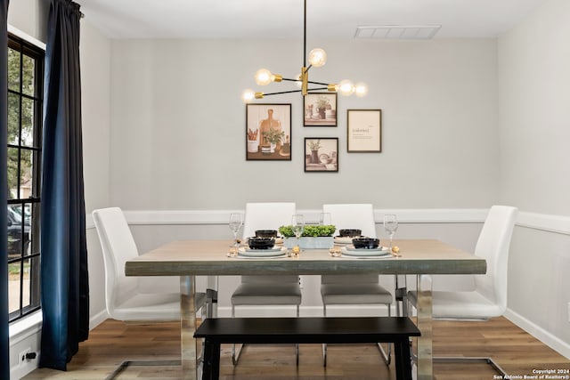 dining room with hardwood / wood-style flooring and an inviting chandelier