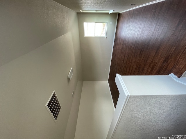 stairs with a textured ceiling and carpet floors