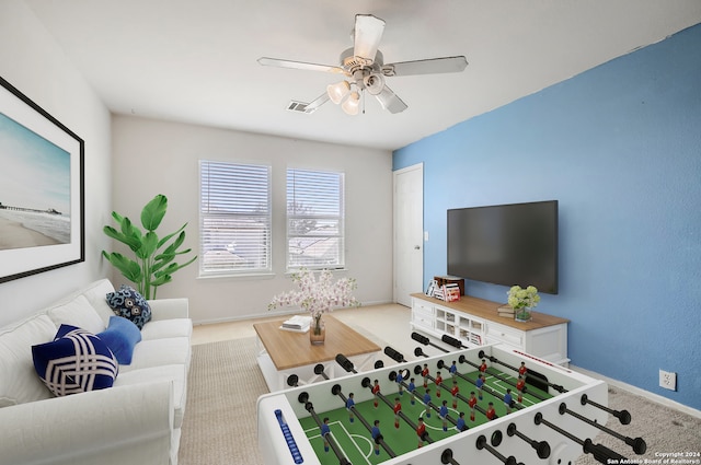 rec room with ceiling fan and light carpet