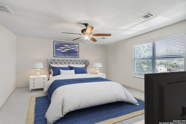 carpeted bedroom featuring a textured ceiling and ceiling fan