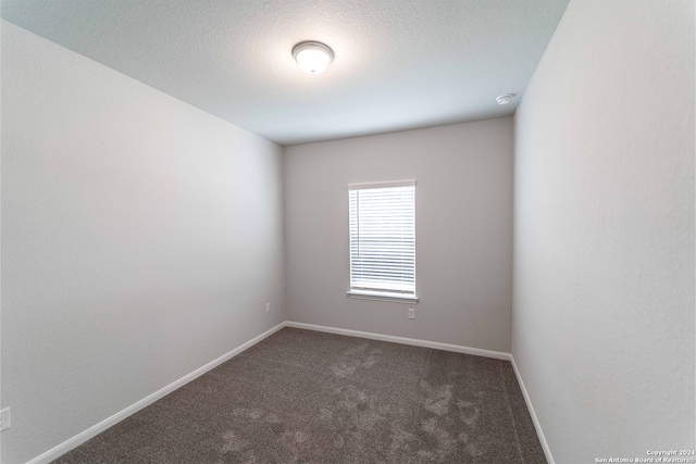 carpeted spare room featuring a textured ceiling