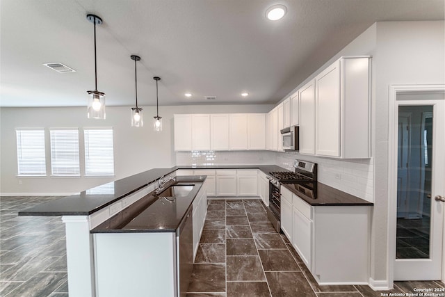 kitchen featuring appliances with stainless steel finishes, backsplash, decorative light fixtures, and white cabinets