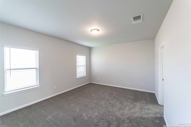 carpeted empty room with a textured ceiling