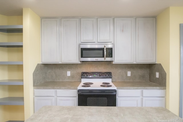 kitchen featuring electric stove, backsplash, and white cabinetry