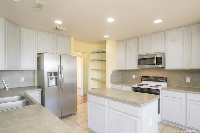 kitchen featuring white cabinets, appliances with stainless steel finishes, decorative backsplash, and sink