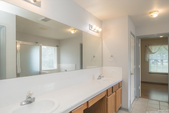 bathroom featuring a shower with shower door, tile patterned flooring, and vanity