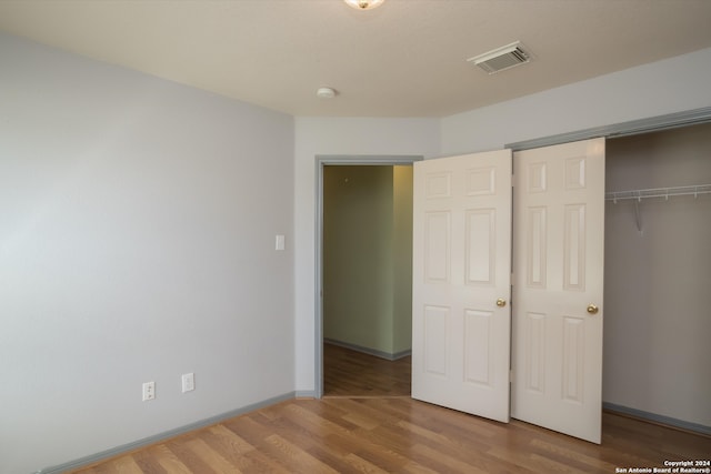 unfurnished bedroom with a closet and wood-type flooring