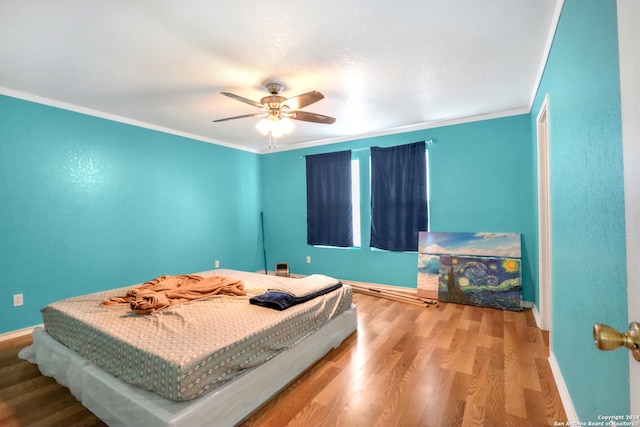 bedroom with wood-type flooring, crown molding, and ceiling fan