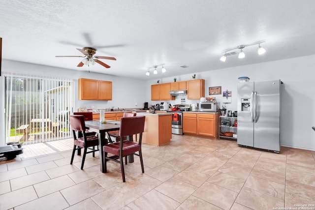 tiled dining area with ceiling fan, a textured ceiling, sink, and rail lighting