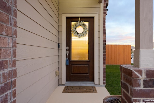 doorway to property featuring fence