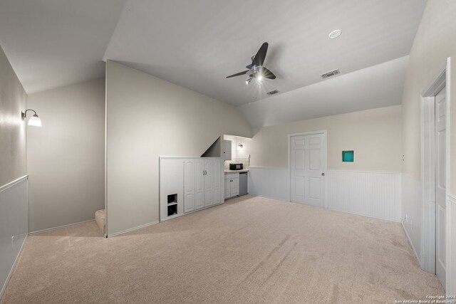 interior space with lofted ceiling, light colored carpet, and ceiling fan