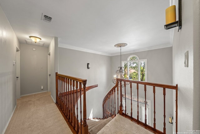 hall featuring crown molding, a notable chandelier, and carpet floors