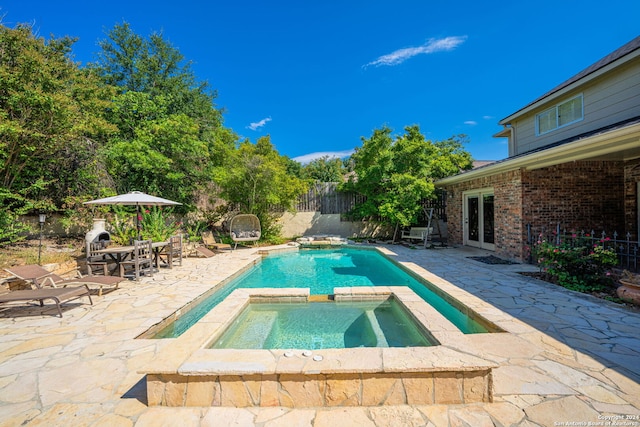 view of pool with a patio area and an in ground hot tub