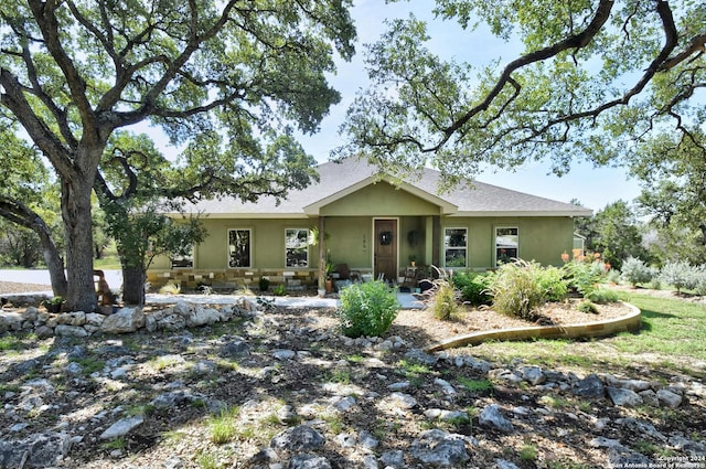 view of front of home featuring stone siding, a shingled roof, and stucco siding