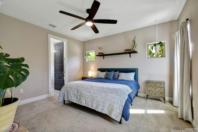 carpeted bedroom with a ceiling fan, visible vents, and baseboards