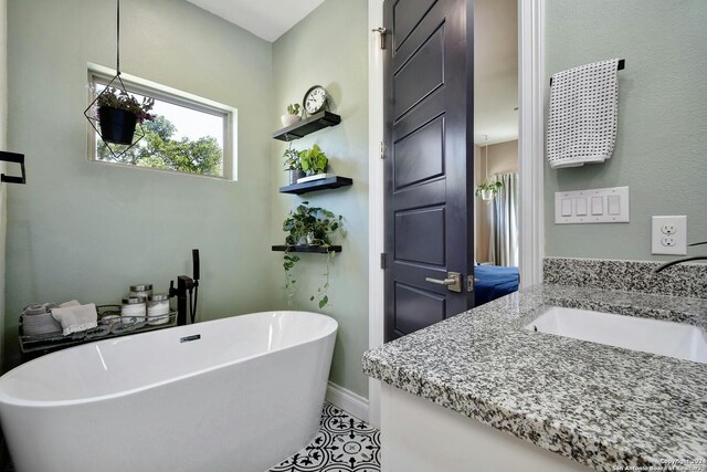 bathroom with tile patterned flooring, vanity, and a bathtub