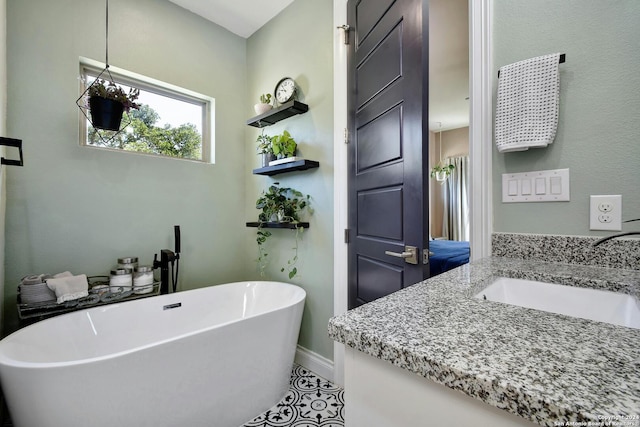 bathroom with a soaking tub, baseboards, and vanity